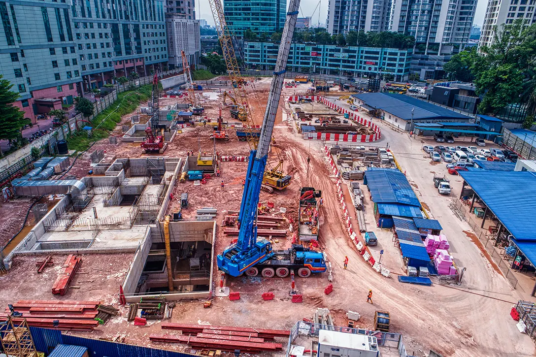 Aerial view of installation of steel struts between plant room and upper platform level of the Ampang Park MRT Station.