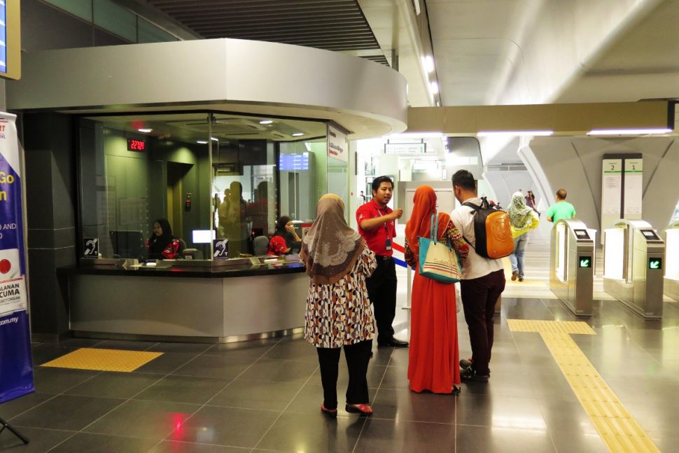 Friendly customer service officer answering queries from the commuters