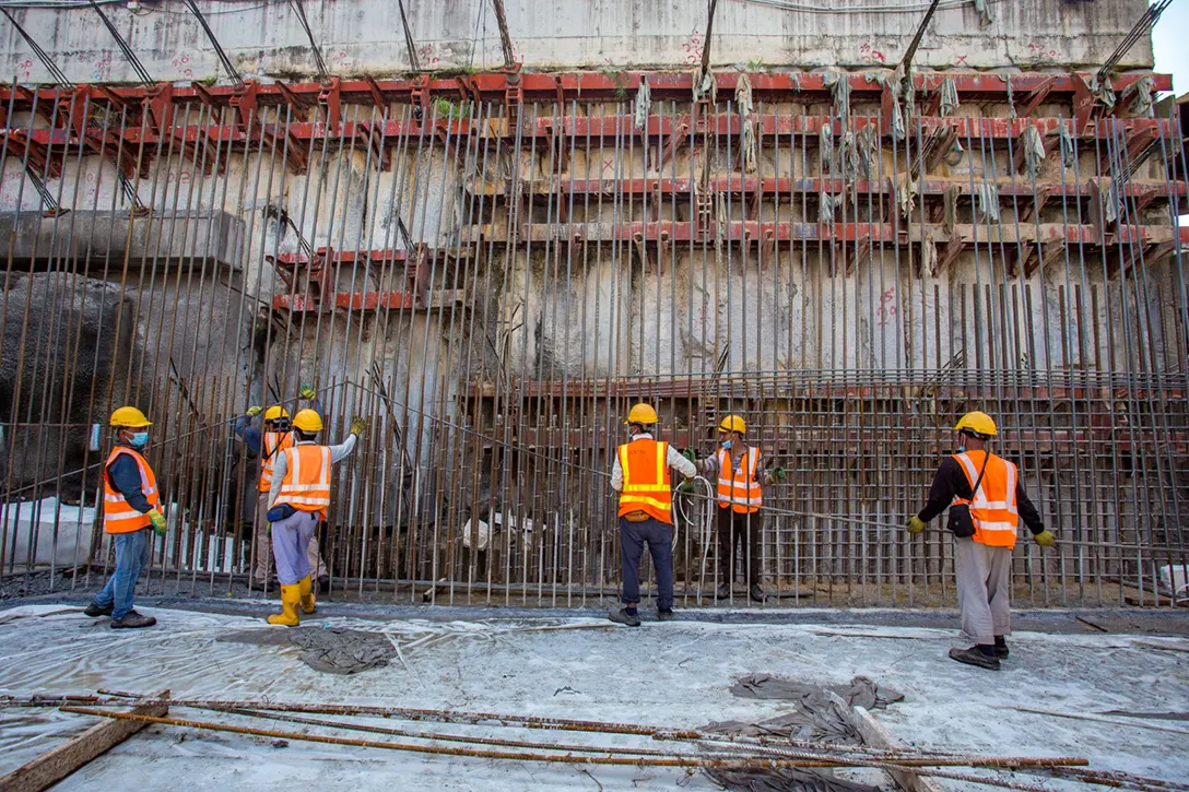 View of the Bandar Malaysia Utara MRT Station site showing construction of ongoing reinforced concrete wall, underplatform wall and column. Also seen is removal of ground anchor and strutting in progress.