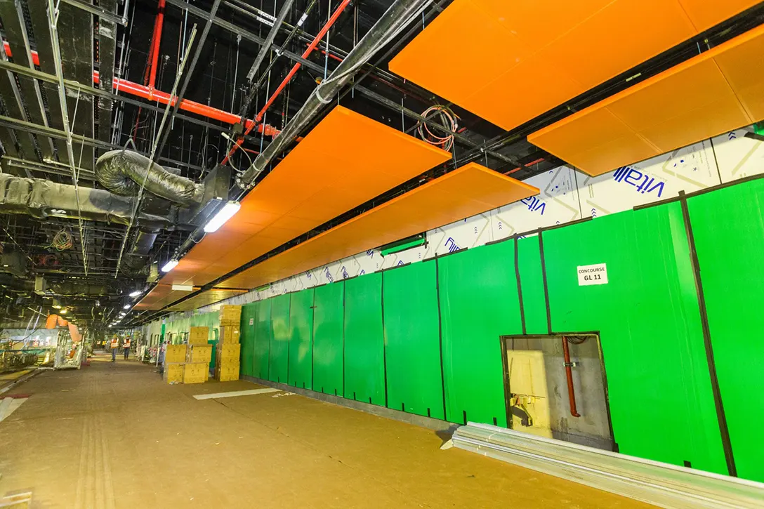 View of the Chan Sow Lin MRT Station showing the installation of ceiling panels in progress at the concourse level.