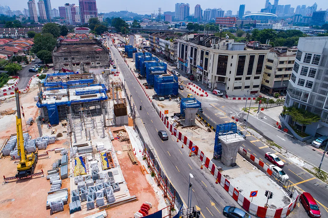 View of launching activity threading and stressing works in progress as well as station building construction at the Kentonmen MRT Station site