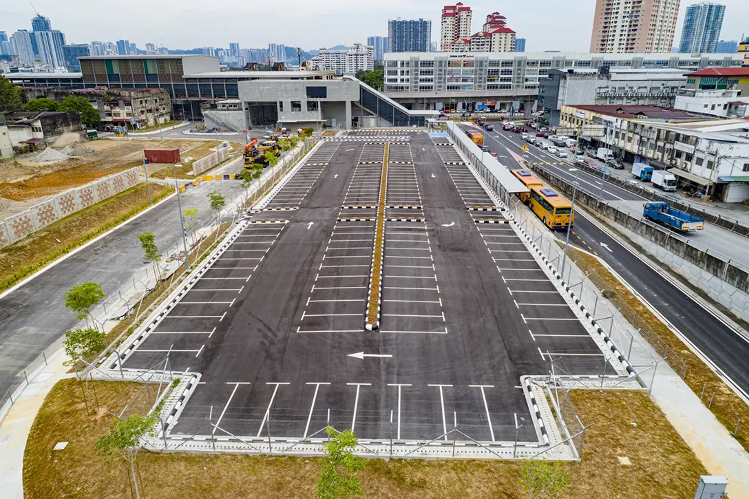 Aerial view of the at-grade park and ride Kentonmen MRT Station showing the laying premix asphaltic concrete wearing course and defects works in progress.