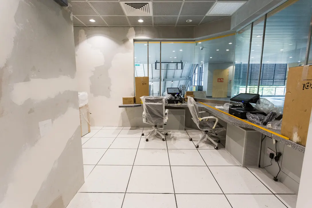 View inside the Kentonmen MRT Station showing the touch-up paint works at the Customer Service Office room in progress.