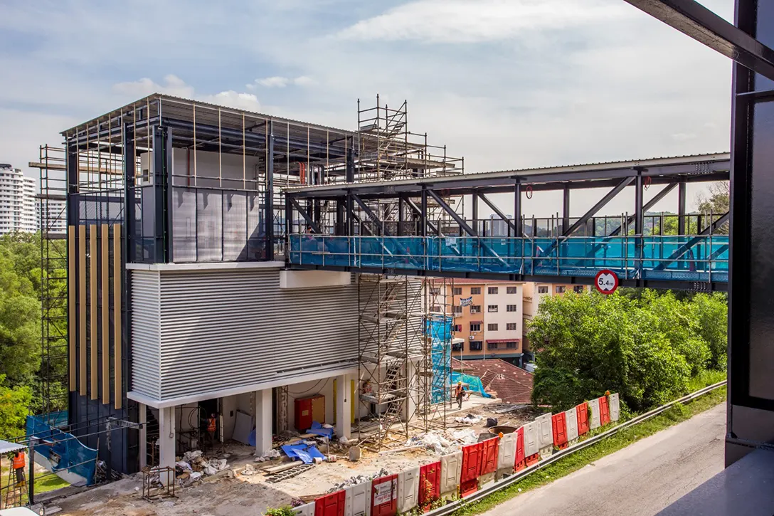 View of the pedestrian link bridge of Putra Permai MRT Station showing the architectural works and finishes in progress.