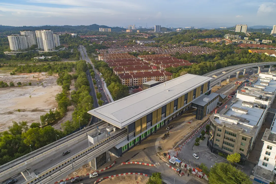 Aerial view of the Putra Permai MRT Station showing the final architectural finishing in progress.