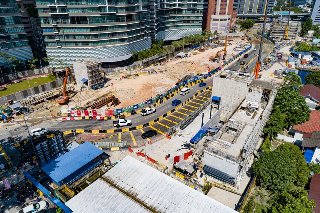 Aerial view of the Raja Uda MRT Station showing the construction of Entrance A and Ventilation Building A reinforced concrete structure in progress.