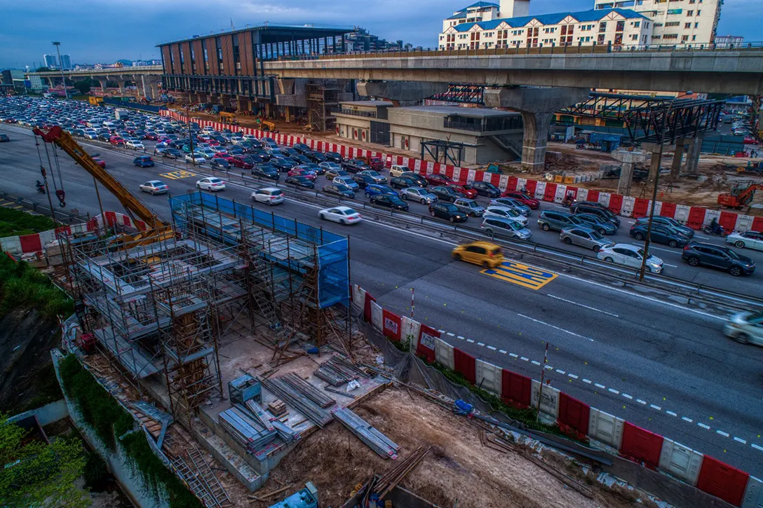 Aerial view of the Serdang Raya Utara MRT Station showing the installation of pedestrian overhead bridge works and Entrance B in progress.