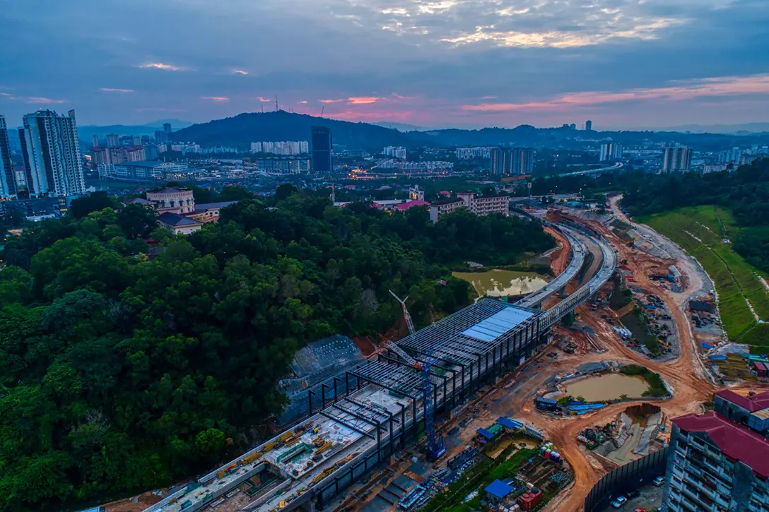 Aerial view of the Taman Naga Emas MRT Station site showing the installation of steel structure and roof sheeting in progress.