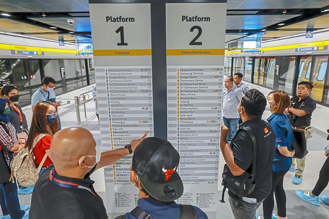 Check points: The media members looking at the route board, as they rode along with Mohd Zarif (below) during the preview of the Putrajaya MRT line.